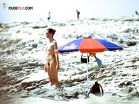 The natural light of the shore enhancing the beauty of a topless model on the sand. 2