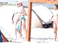 The natural light of the shore enhancing the beauty of a topless model on the sand. 2