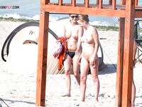 The natural light of the shore enhancing the beauty of a topless model on the sand. 2