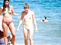 Two Topless Women Chatting by Clear Blue Water