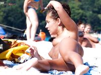Topless opalování na písku v oranžových spodních dílech bikiny
