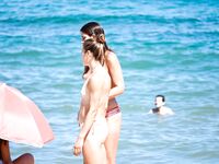 Vysoký drdol, kočičí brýle a topless písek za ní