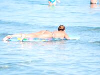 Vysoký drdol, kočičí brýle a topless písek za ní