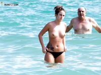 In piedi topless insieme nell'acqua bassa in spiaggia