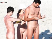 Three Nudists Sharing Sunscreen by the Shore