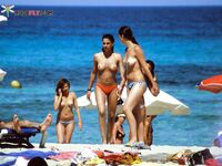 A serene gaze toward the horizon, enjoying the sea air in a topless fashion.