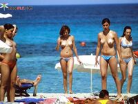 A serene gaze toward the horizon, enjoying the sea air in a topless fashion.