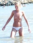 A serene gaze toward the horizon, enjoying the sea air in a topless fashion.