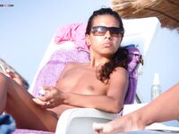 Lounging Topless on a Sandy Beach Chair With a Purple Towel