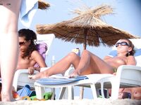 Lounging Topless on a Sandy Beach Chair With a Purple Towel