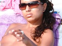 Lounging Topless on a Sandy Beach Chair With a Purple Towel