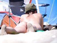 Lounging Topless on a Sandy Beach Chair With a Purple Towel