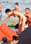 Cappellino da baseball al limitare dell'onda sulla spiaggia nuda