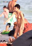 Cappellino da baseball al limitare dell'onda sulla spiaggia nuda