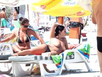 Two Nudists Smiling on Towels in Cap and Bandana