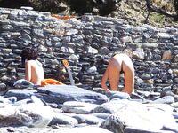 Two Nudists Smiling on Towels in Cap and Bandana