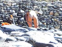 Two Nudists Smiling on Towels in Cap and Bandana