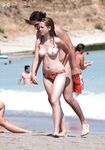 Sitting Upright on a Topless Beach with Hair in a Bun