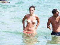 Sitting Upright on a Topless Beach with Hair in a Bun