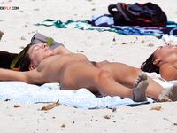 A topless lady observing the waves from a quiet, elevated coastal viewpoint. 3
