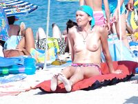 Orange Towel and Striped Bikini Bottoms on a Busy Topless Shoreline
