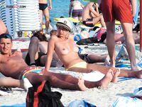 Orange Towel and Striped Bikini Bottoms on a Busy Topless Shoreline