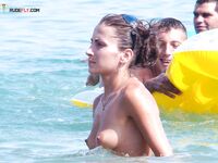 Orange Towel and Striped Bikini Bottoms on a Busy Topless Shoreline