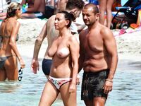 Stojící v mělké vodě v květinových spodních dílech bikiny