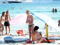 Soft sand and golden skin: a peaceful morning spent in a classic topless fashion.