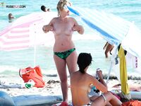 Soft sand and golden skin: a peaceful morning spent in a classic topless fashion.