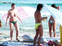Soft sand and golden skin: a peaceful morning spent in a classic topless fashion.