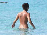 Posing with confidence in a state of total, liberated nudity by the sea. 2