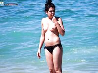 A lady enjoying a peaceful moment at a secluded, clothing-optional cove. 4