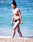 A lady enjoying a peaceful moment at a secluded, clothing-optional cove. 4