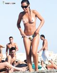 Three Topless Women Pose as One Lifts a Compact Camera