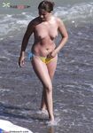 A lady enjoying a tropical-style beach in a traditional topless manner.