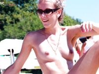 Spreading a Turquoise Towel on Wet Sand at the Nude Beach Shore