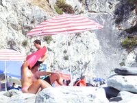 From Sea to Pebble Shore Beside a Yellow Umbrella and Towel