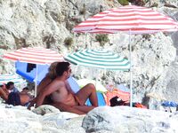 From Sea to Pebble Shore Beside a Yellow Umbrella and Towel