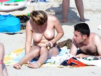 Boné Verde e Areia de Verão Junto a um Guarda-sol Coca-Cola na Praia Nudista