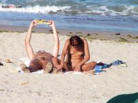 Two Nudists Unwind on Towels as Waves Roll In