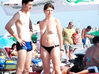 Eating a Peach Slice on the Sand at a Sunny Topless Beach