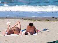 A lady enjoying the ultimate sunbathing experience at a clothing-optional spot. 3