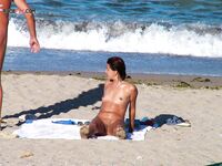 A lady enjoying the ultimate sunbathing experience at a clothing-optional spot. 3