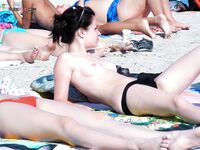Upright Beside a Straw Sunshade on a Midday Topless Beach