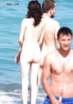 Upright Beside a Straw Sunshade on a Midday Topless Beach