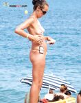 Applying Sunscreen Topless in Orange Bikini Bottoms by the Sea