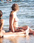 Sitting Topless on a Blue Beach Lounger by the Sea