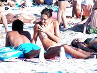 En una toalla con braguita blanca entre bañistas al sol
