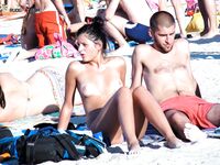 En una toalla con braguita blanca entre bañistas al sol